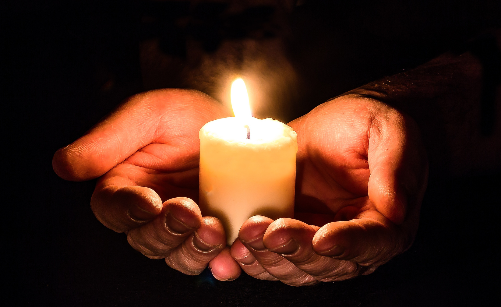 Hand Holding Lit Candle